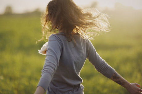 Femme courant dans un champ au soleil, symbole de forme et de vitalité